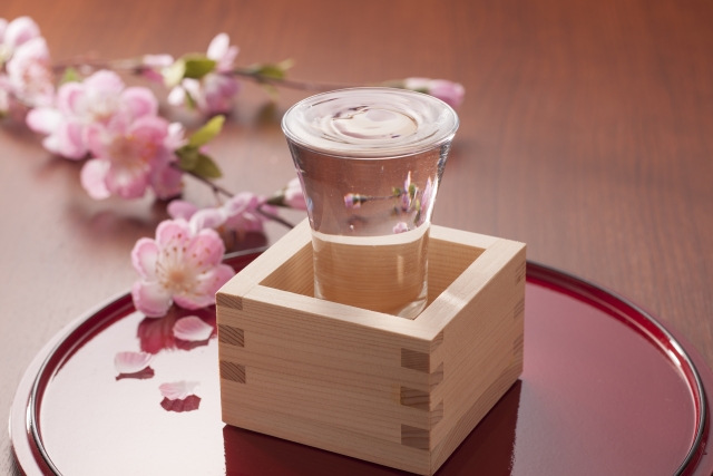 日本酒の入ったグラスと升と桜